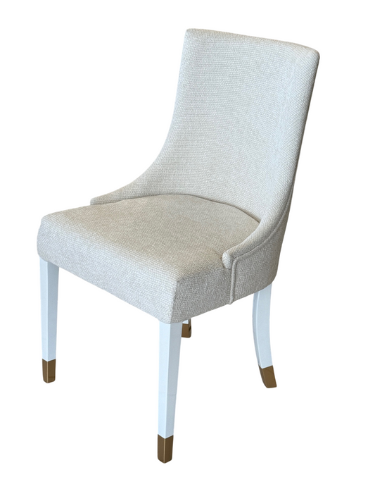 luxury dining chair win ivory fabric with white wooden legs and gold tips.