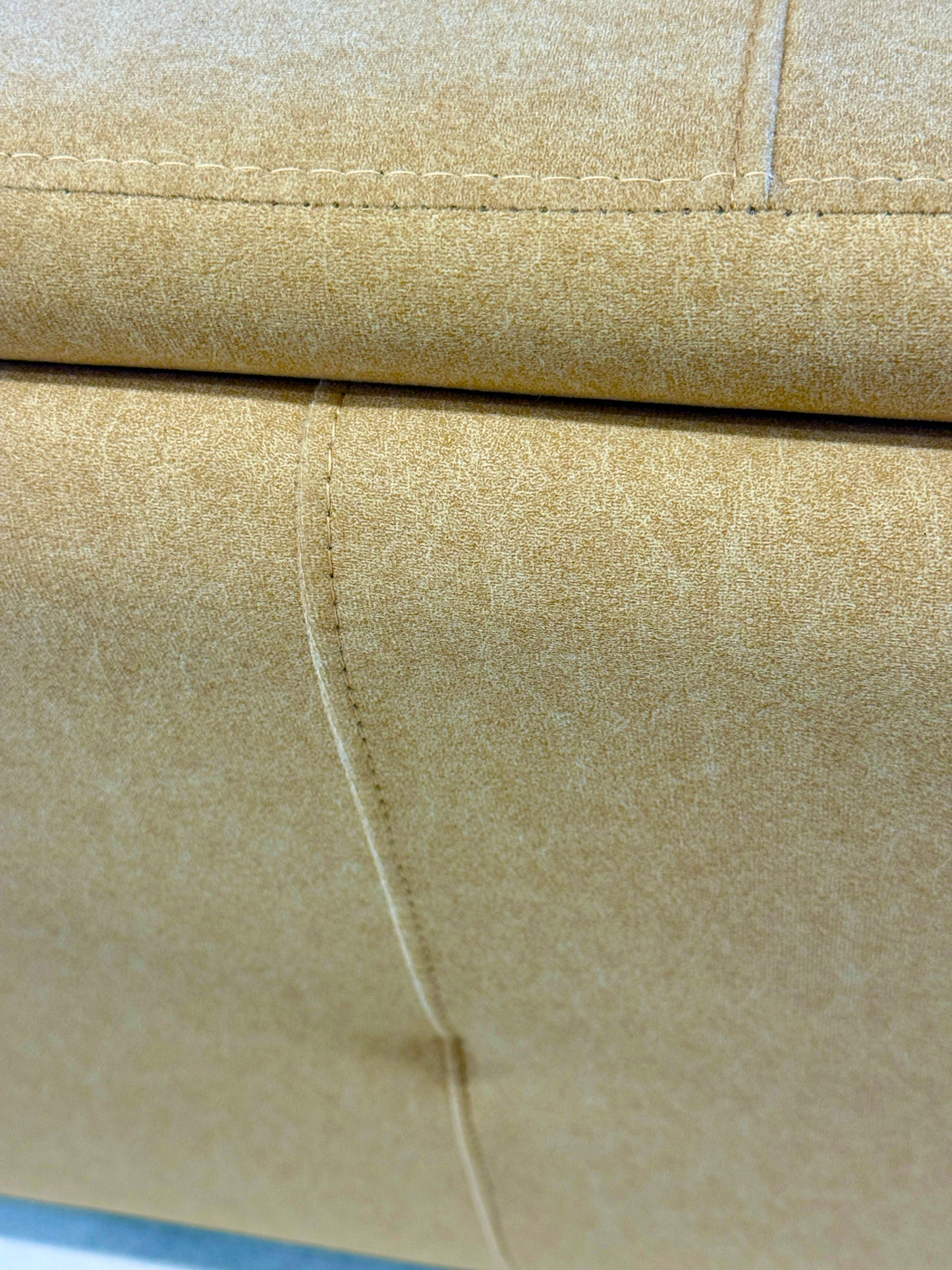 Close-up of beige fabric  of couch with a visible seam