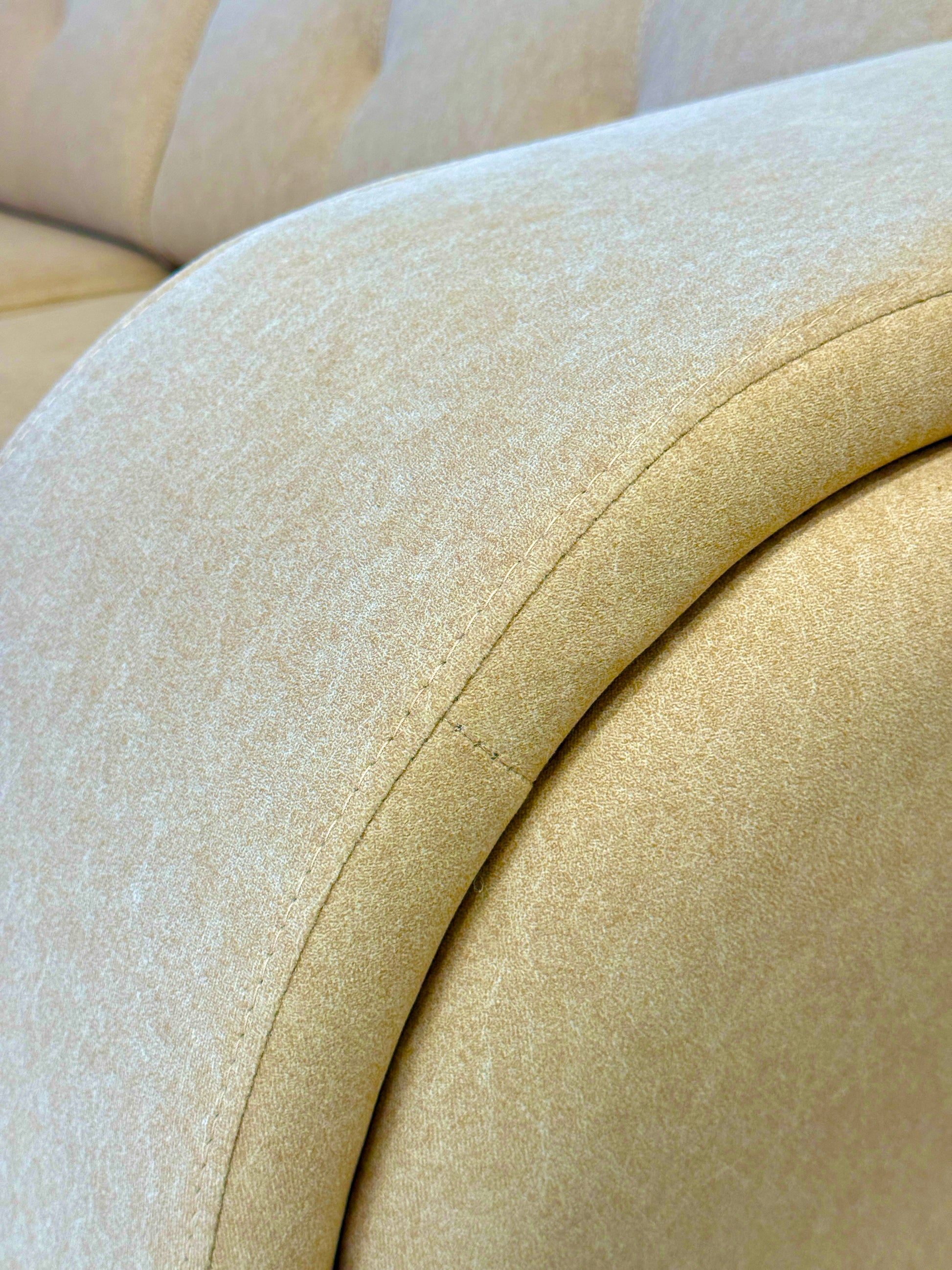 Close-up of a beige upholstered sofa with a focus on the fabric texture.