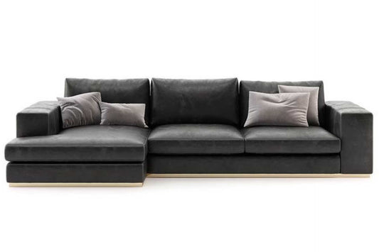 Charcoal leather L shaped couch with stitching detail on arms.