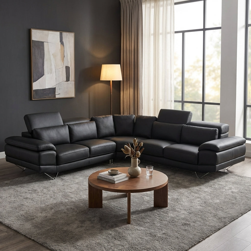 Large black leather corner couch with adjustable headrests and chrome feet.