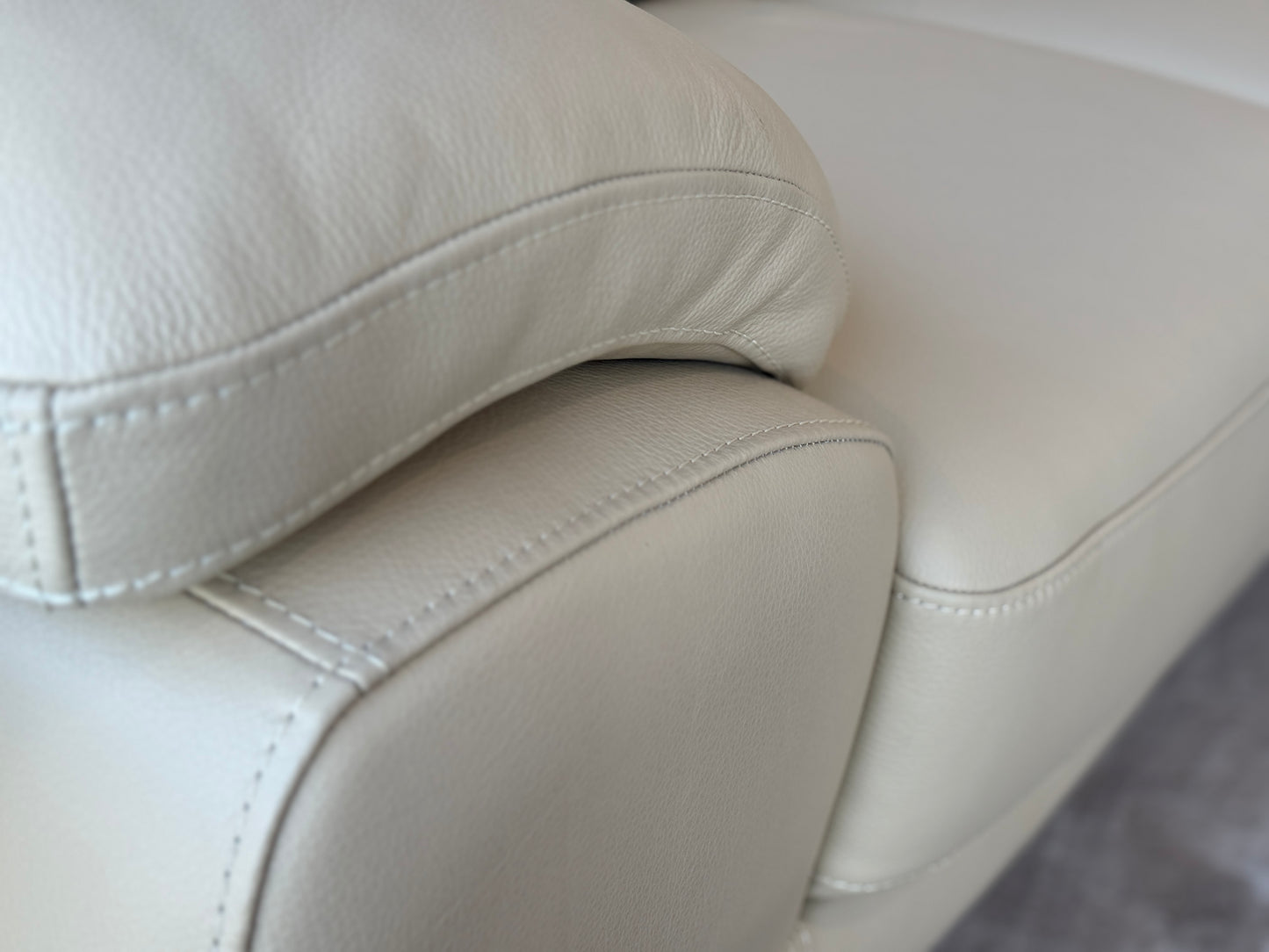 Close up of light grey leather and stitching detail or Dennis corner couch in grey. Galeria Furniture SA