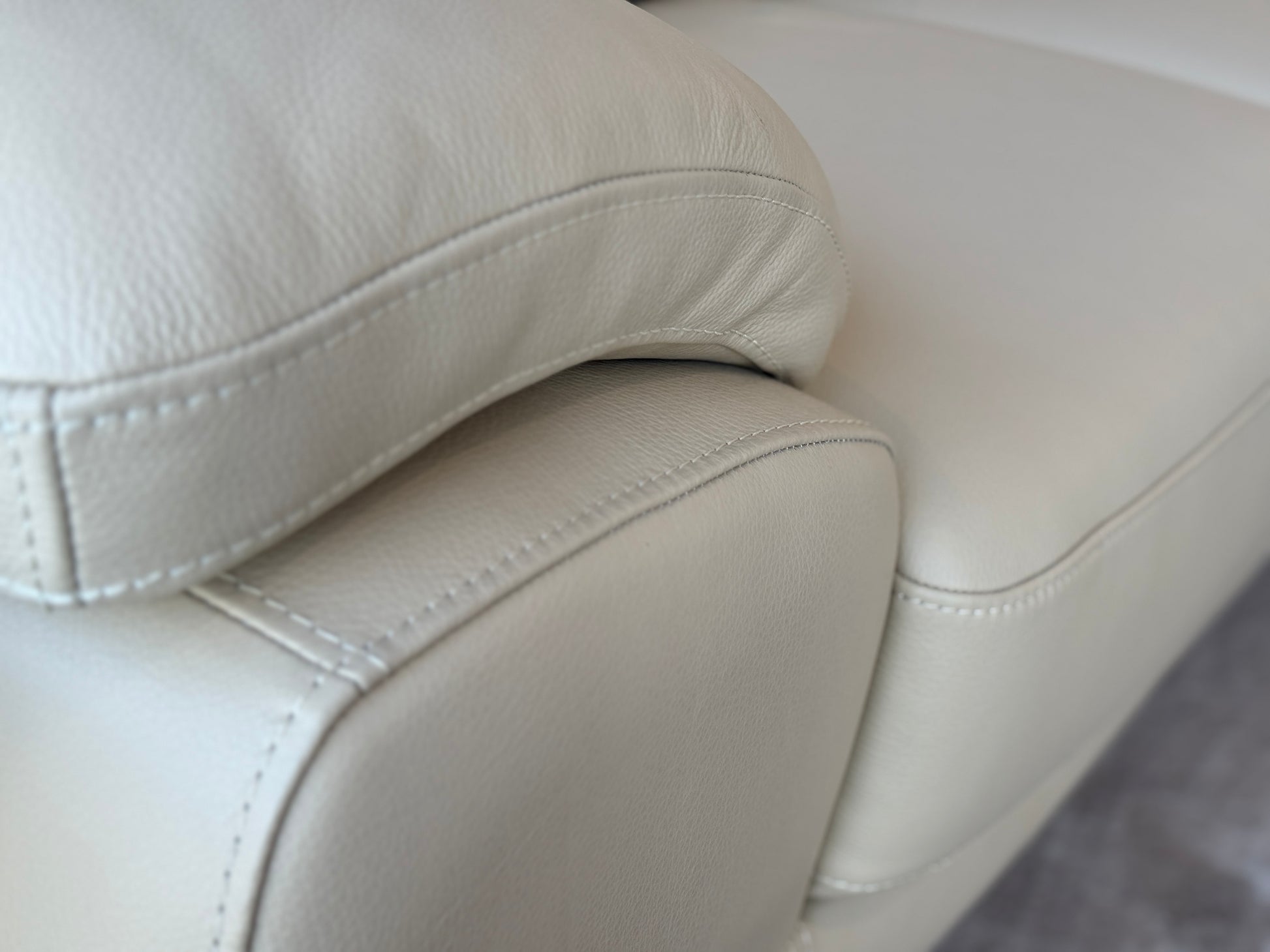 Close up of light grey leather and stitching detail or Dennis corner couch in grey. Galeria Furniture SA