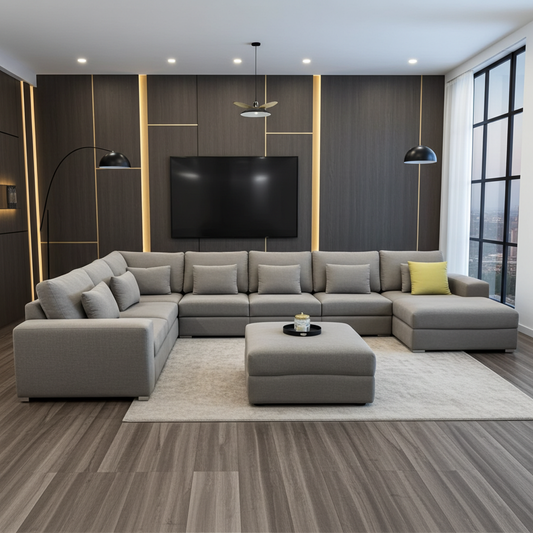 Large corner couch with loose ottoman, upholstered in luxury grey fabric.