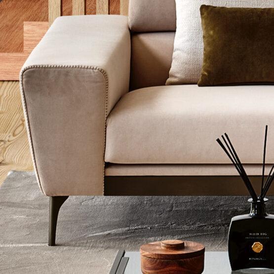 Beige fabric sofa with gold brass metal strip and gold brass legs.