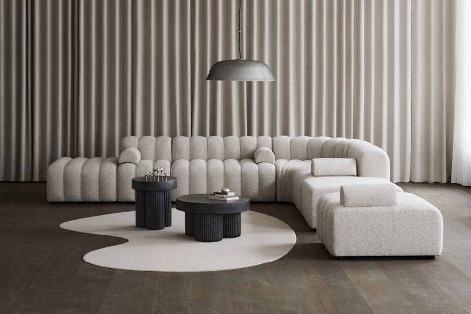 Corner couch in boucle fabric with a channel design and loose armrests. This corner couch has a matching ottoman included.