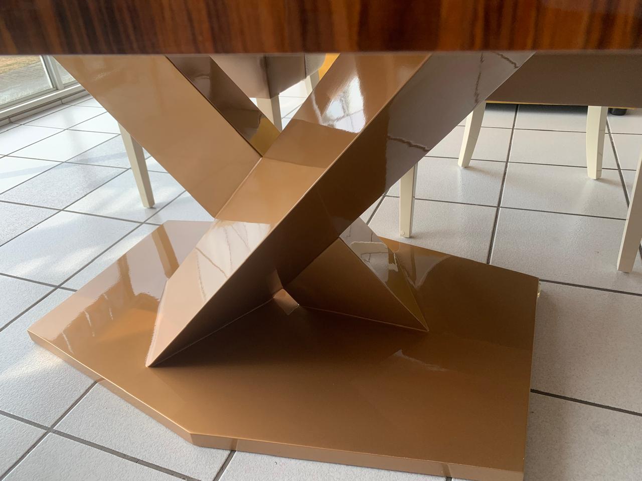 Glossy gold criss-cross table legs.