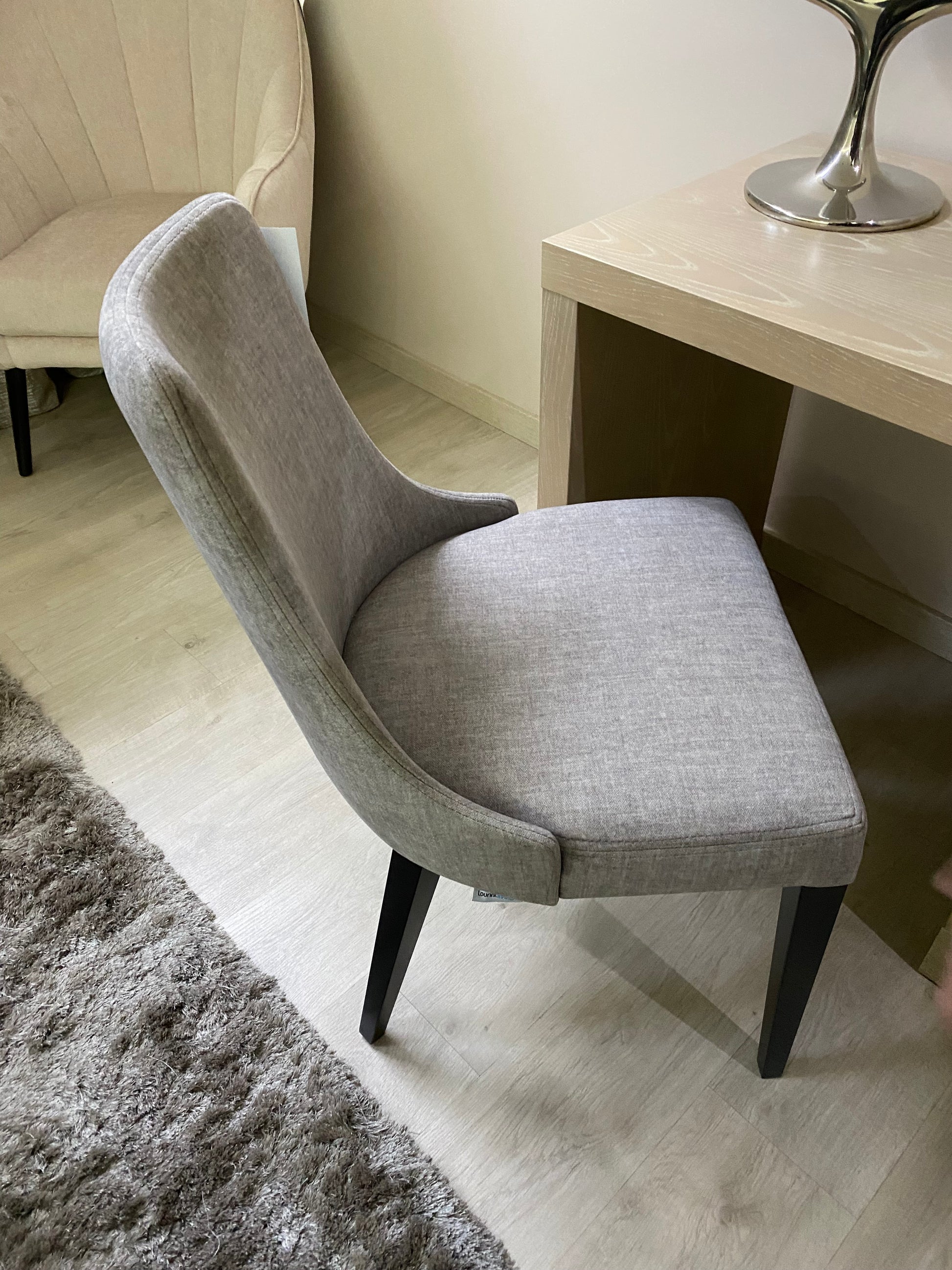 grey fabric dining chair with black wooden legs. European design, exclusive to Galeria Furniture in Mbombela.