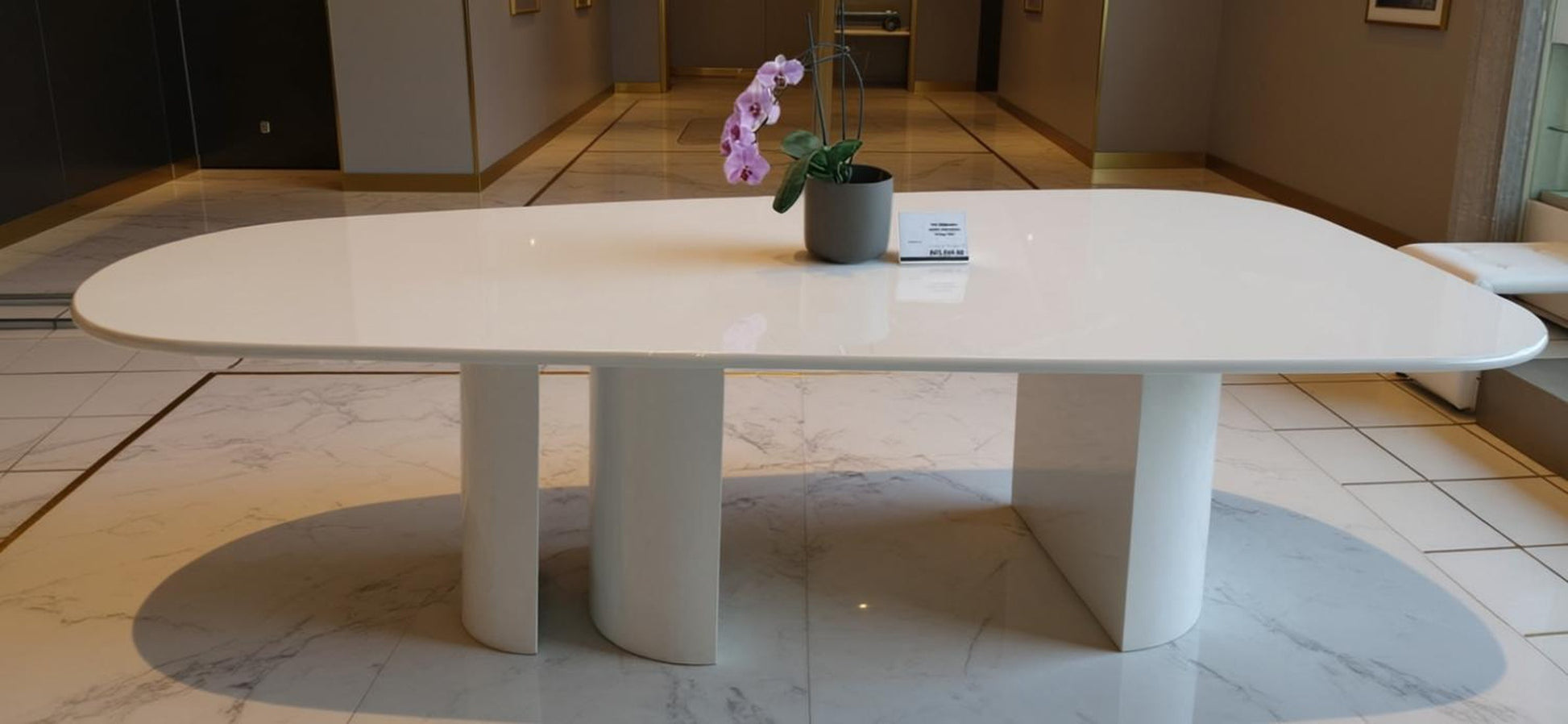 Luxury dining table in gloss white with 3 pillar legs and oblong table top. Handcrafted in Europe.