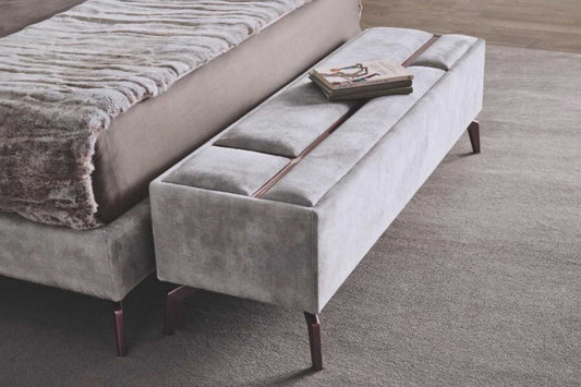 Bedroom ottoman upholstered in luxury grey fabric with rose gold metallic detail