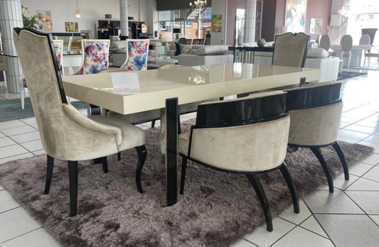 6-8 seater dining table in a gloss beige finish with black legs.