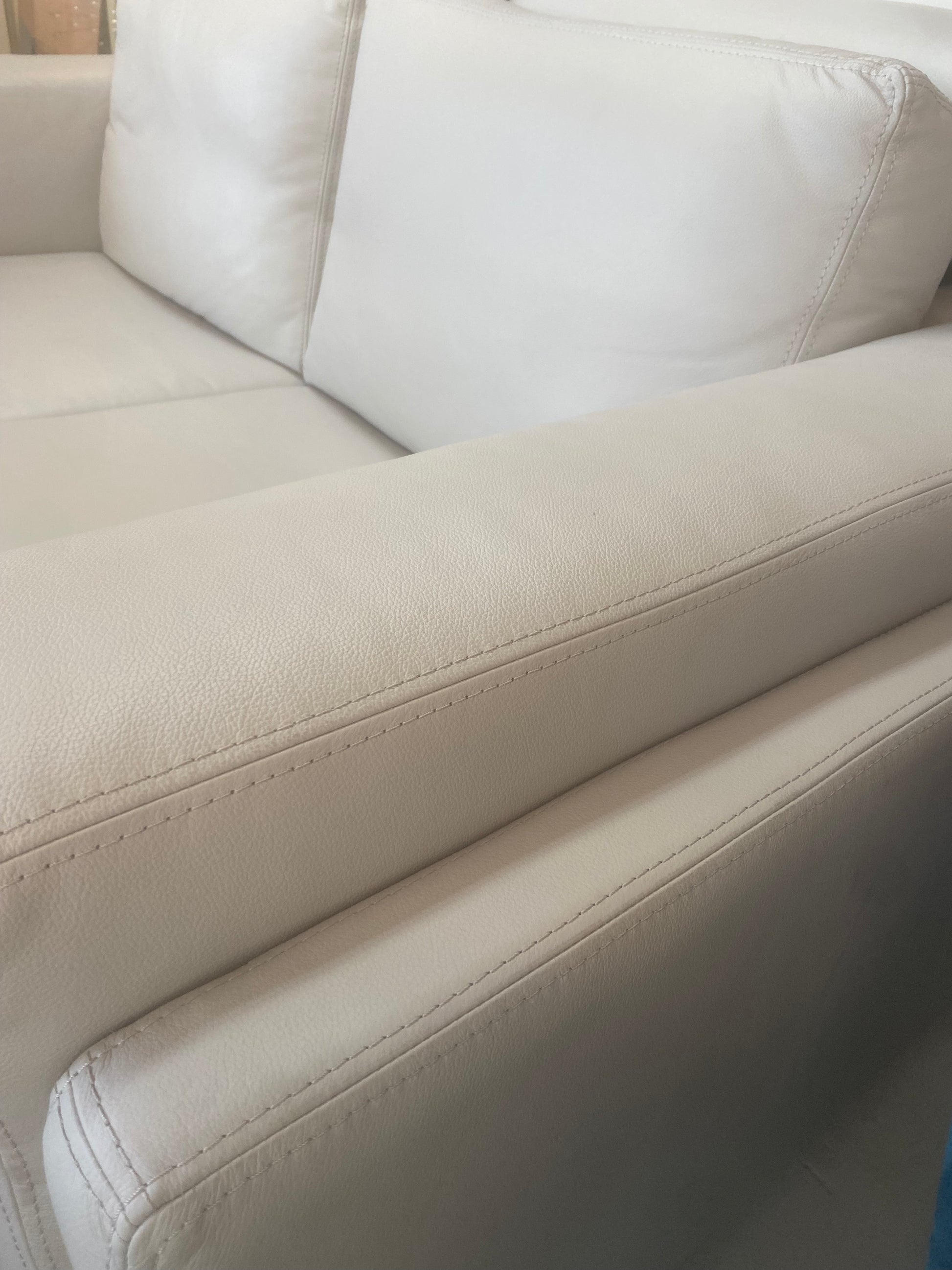 Light grey leather couch with stitching detail